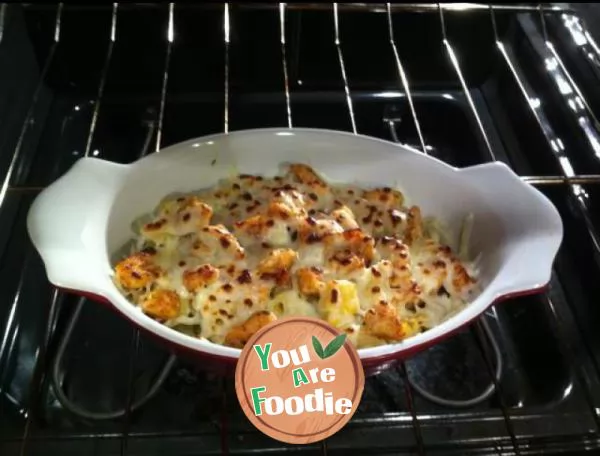 Baked spaghetti with cheese, diced chicken and vegetables