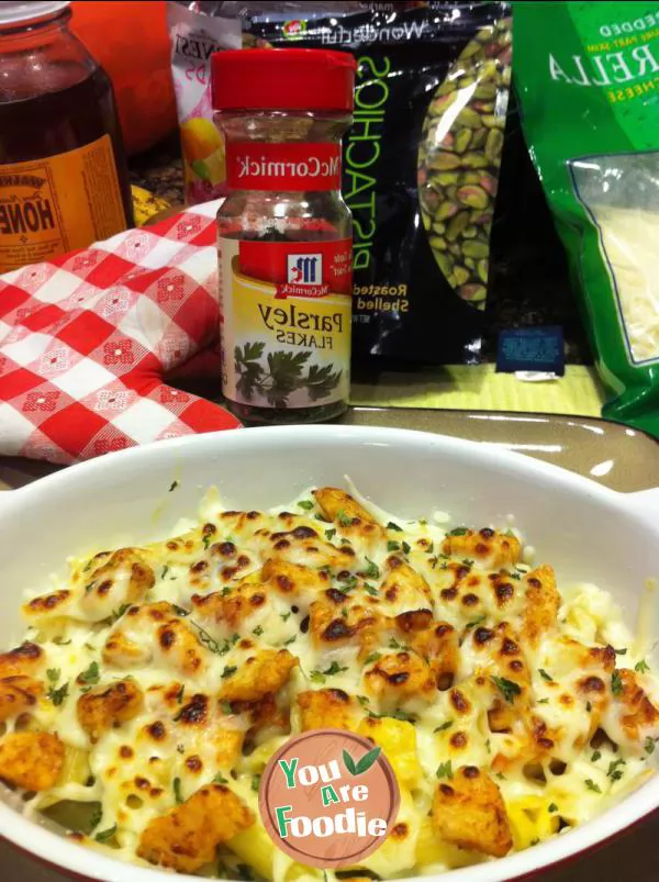 Baked spaghetti with cheese, diced chicken and vegetables