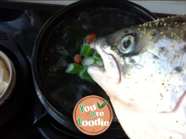 Salmon head in clear soup in stone pot