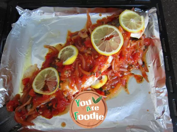 Grilled fish in tomato sauce with lemon